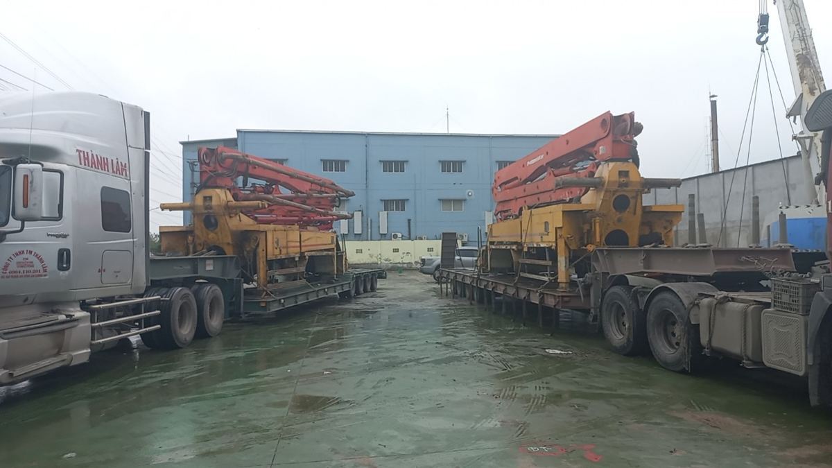 Hai xe đầu kéo chở cần bơm bê tông từ Hà Nội về bãi đóng hàng Hải Phòng