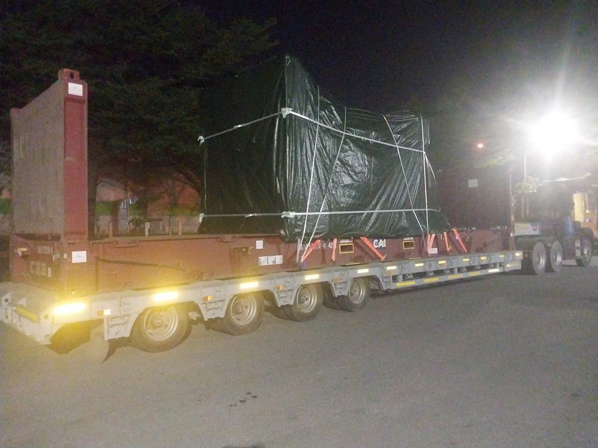 40ft flat rack with covered machinery on a multi-axle lowbed at night, bound for CMIT terminal Cai Mep port