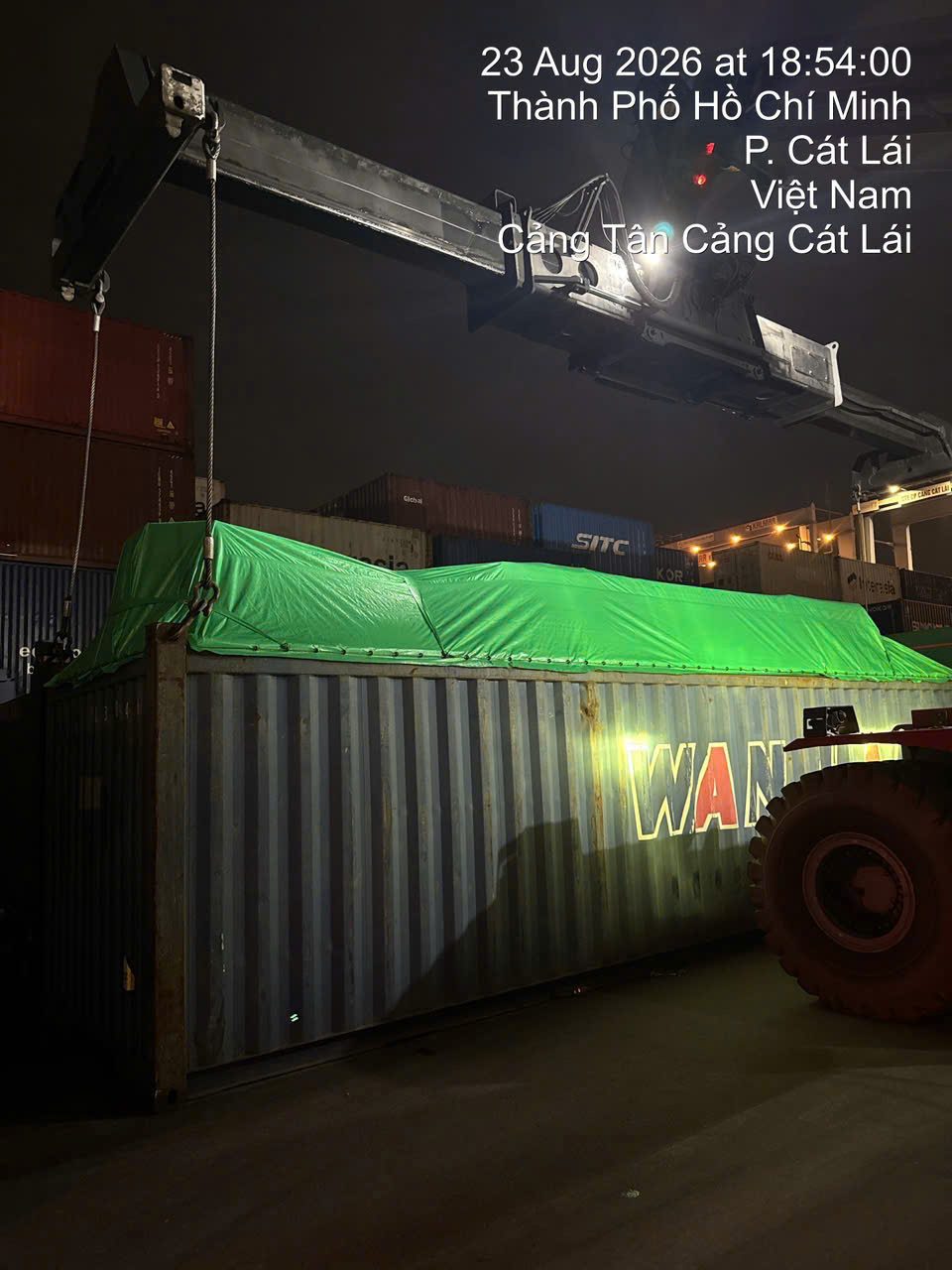 40ft open top container with tarpaulin lifted by reach stacker at Cat Lai port for delivery to Moc Bai
