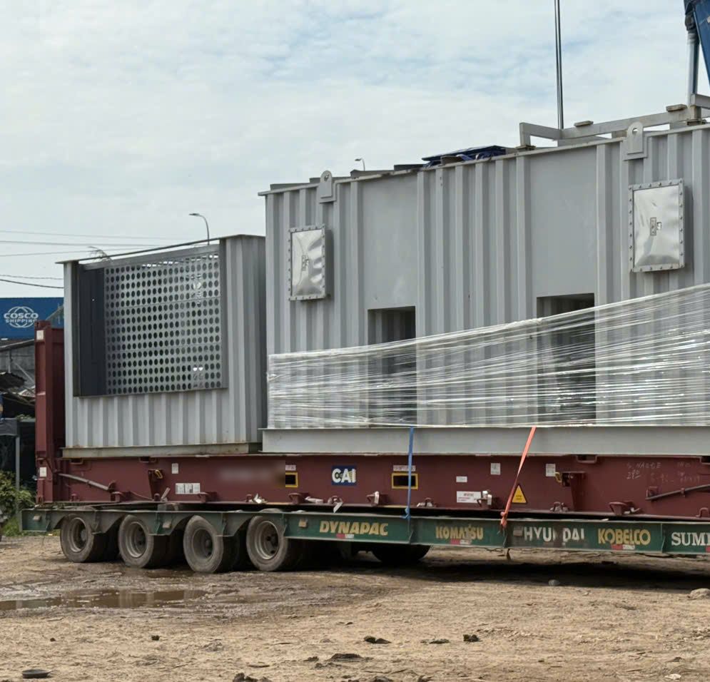 Kiện thiết bị vỏ thép đặt trên sàn cont 40 Flat Rack, quấn màng trước khi chằng
