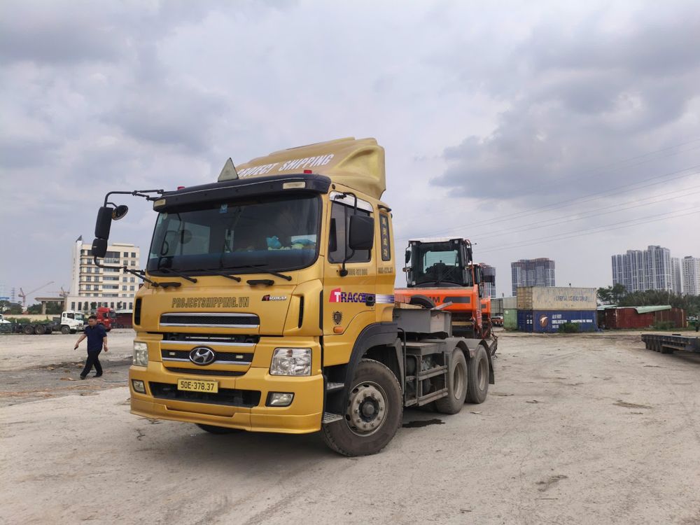 KMTC Local Charges: Project Shipping prime mover with a road roller on its lowbed at Cat Lai port