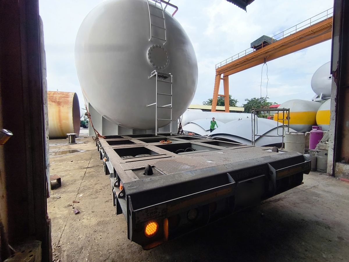 Loaded lowbed with a steel storage tank at a fabrication yard in Bien Hoa before the run to Moc Bai