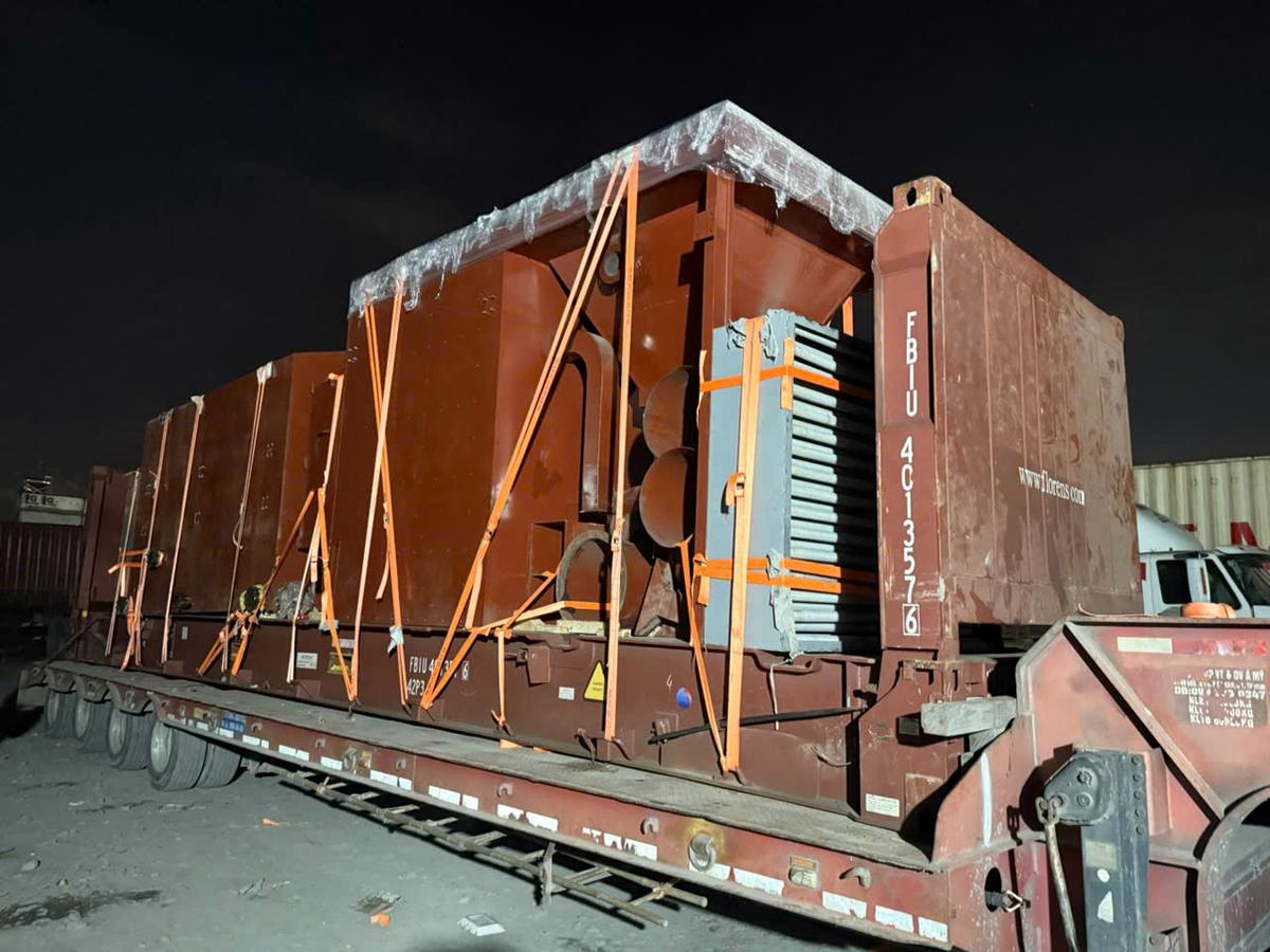 Machinery lashed on a 40ft flat rack on a lowbed at night before the run to Cat Lai port