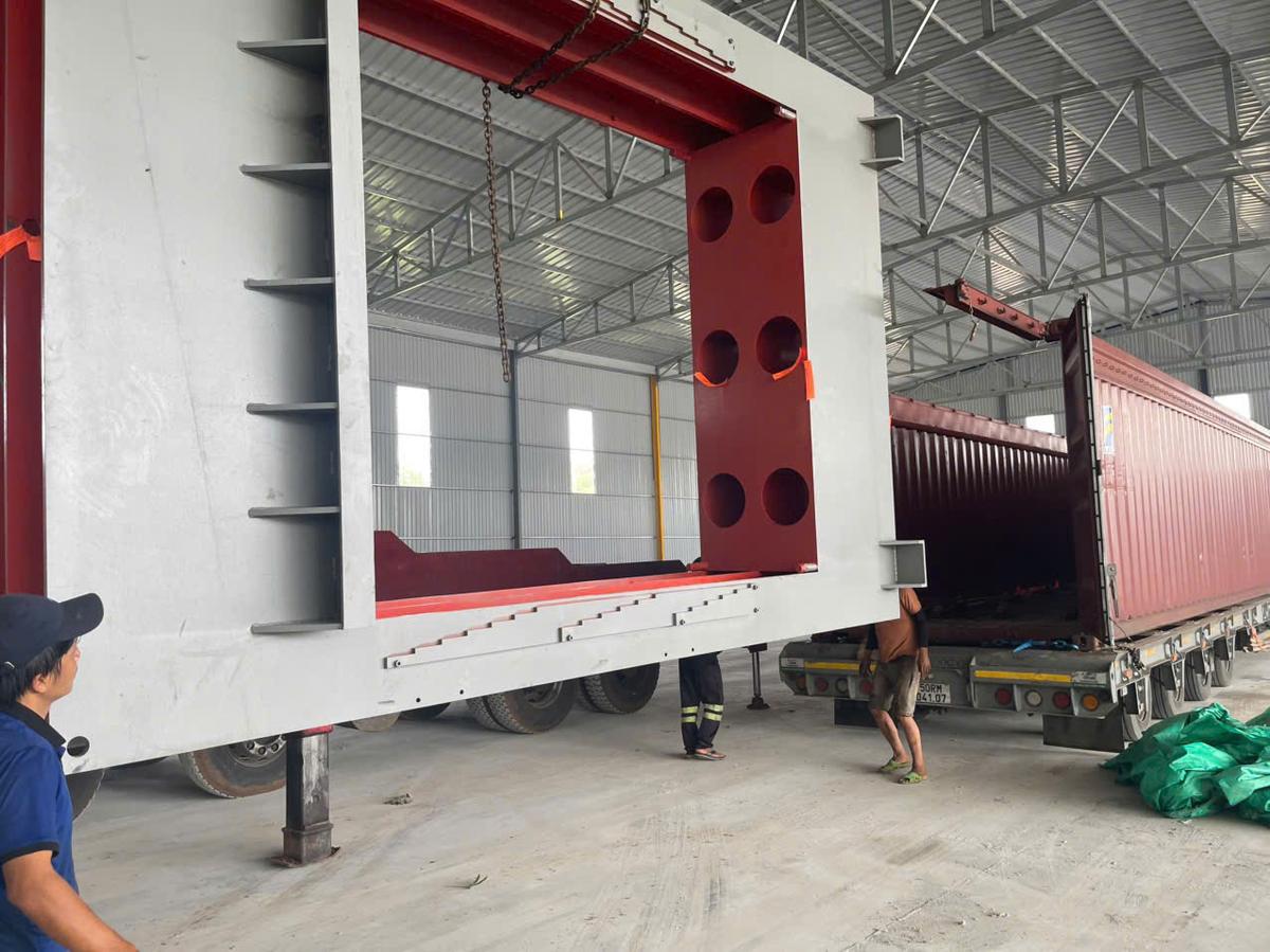 Steel frame lifted out of a 40ft open top container by mobile crane at a factory after Cat Lai port delivery
