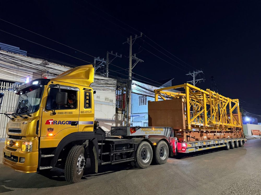 Tower crane loaded on a 40ft flat rack trucked at night from Cat Lai port Vietnam by Project Shipping