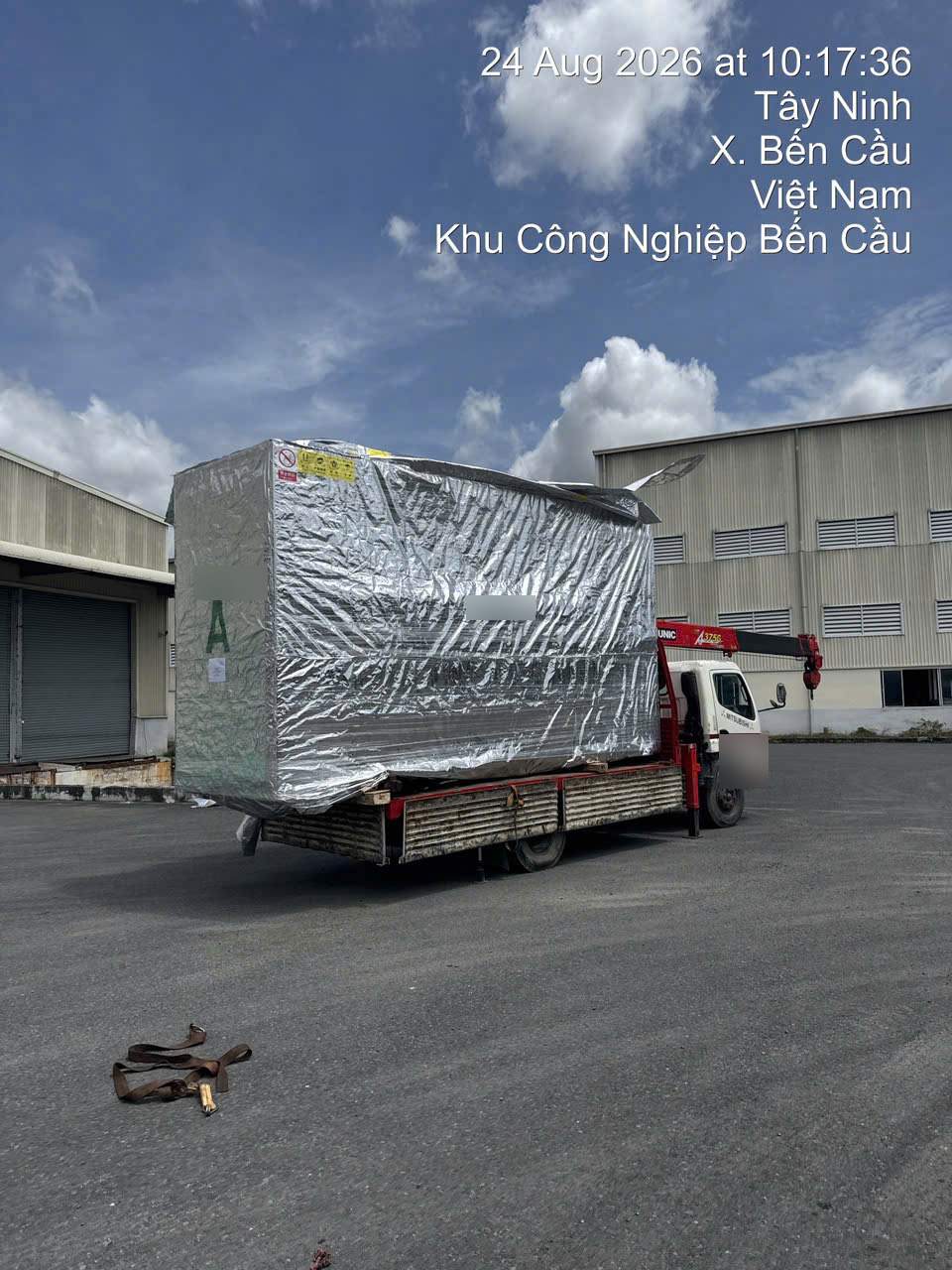 Truck crane unloading foil-wrapped equipment at an industrial park in the Moc Bai border economic zone