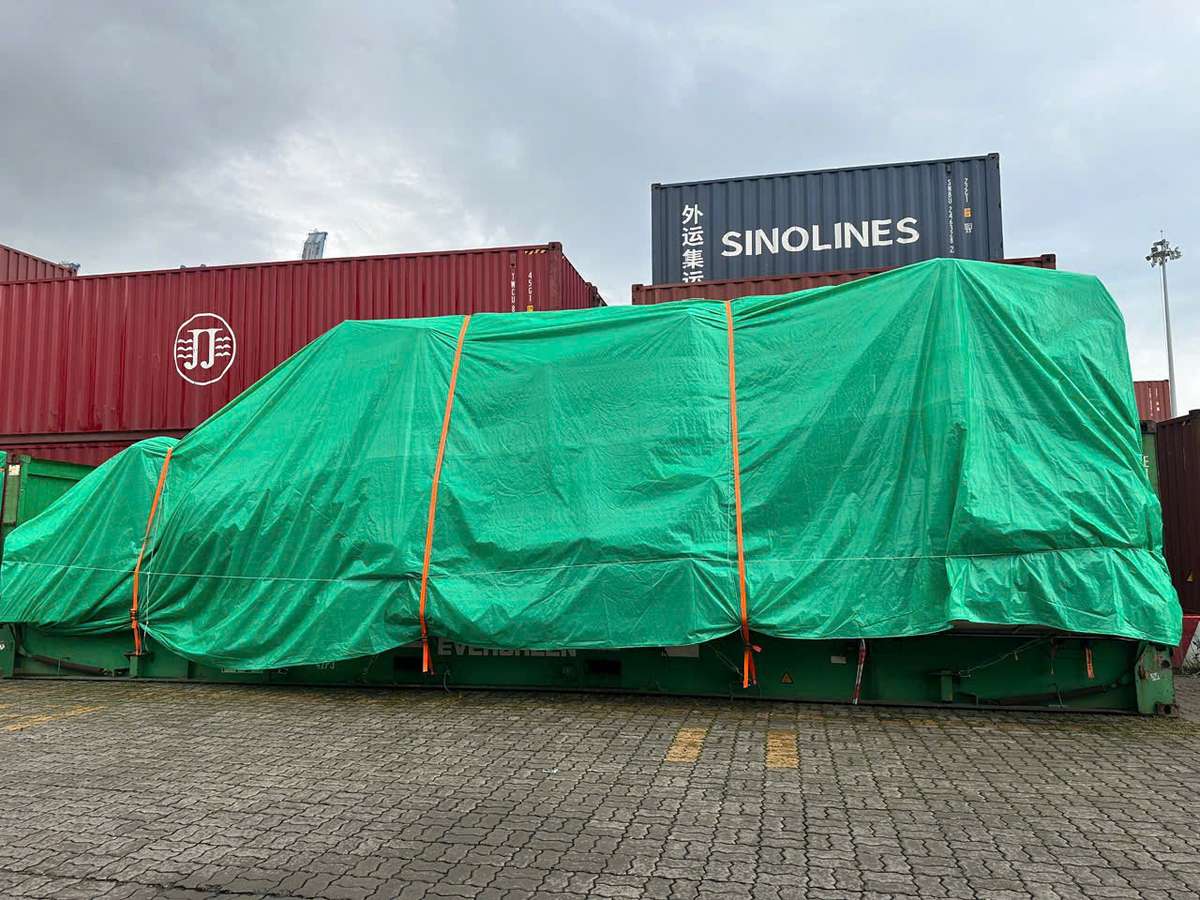 Cont 40 Flat Rack chở kiện hàng phủ bạt xanh tại bãi cảng, chuẩn bị vận chuyển hàng quá khổ Long An