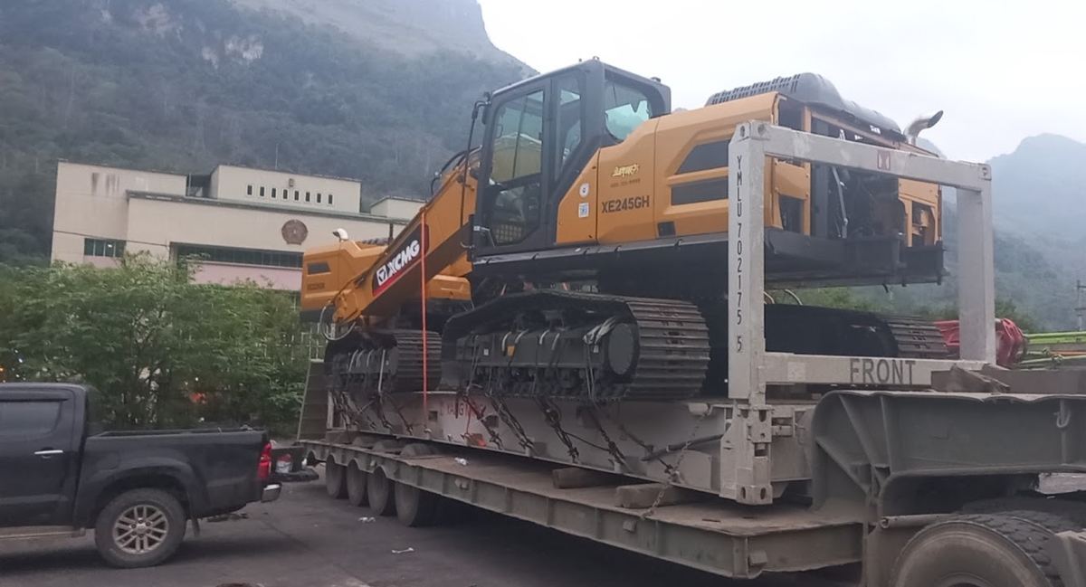 Máy đào bánh xích chằng xích trên Flat Rack trước khi vận chuyển xe chuyên dụng ra cảng